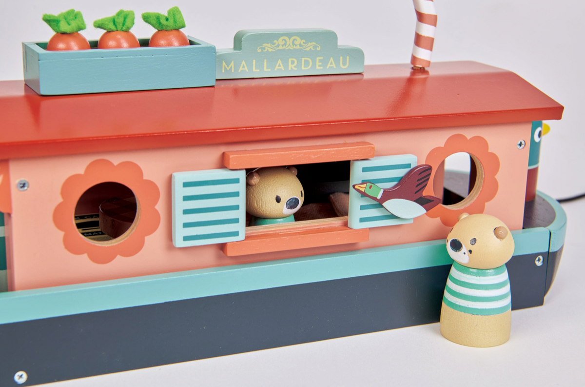 Children's toy boat with compartments and a small figure on a white background