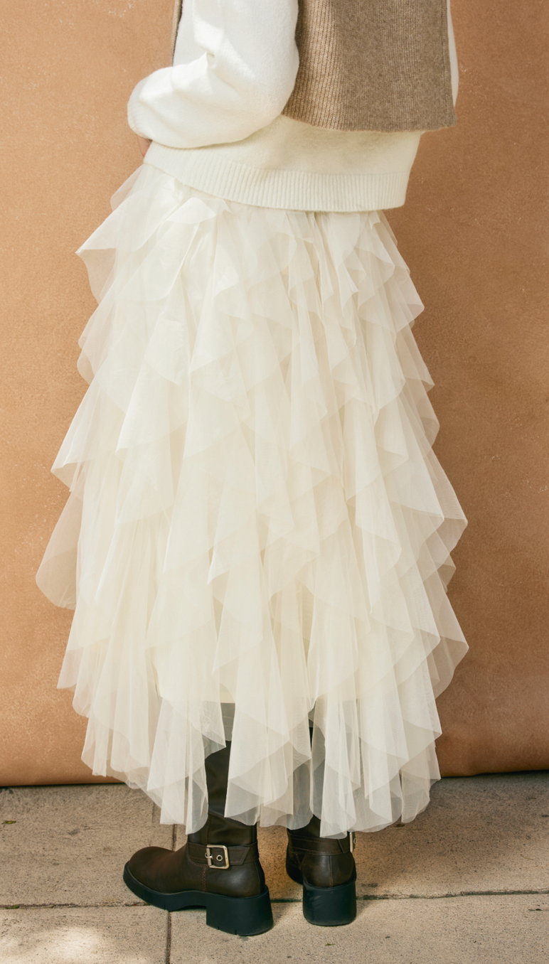 White ruffled skirt worn by a person against a beige background