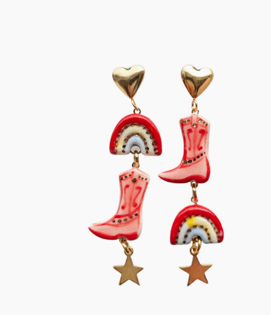 Cowboy boot earrings with rainbow and star charms on a white background