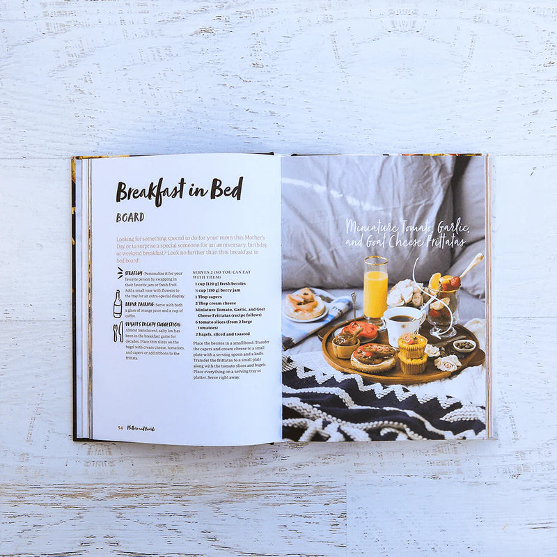 Open book showing a recipe for 'Breakfast in Bed' with a photograph of a breakfast tray on a white wooden surface.