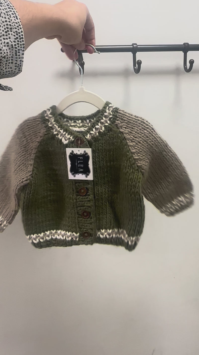 varsity baby knit on a hanger with a white background. 