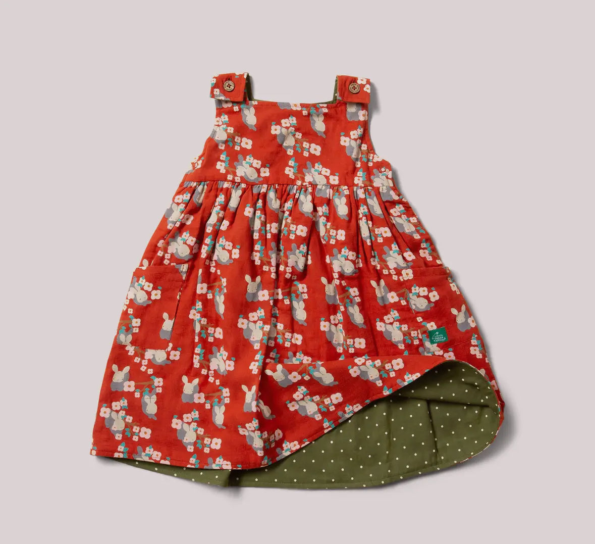 Red floral dress with green polka dot lining on a light gray background