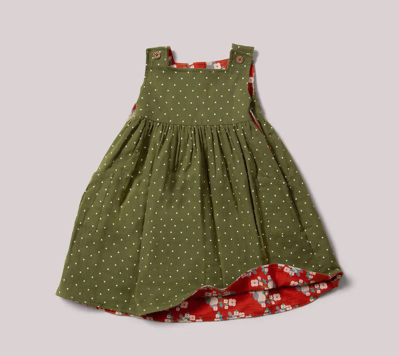 Green dress with white polka dots and red floral pattern on a gray background