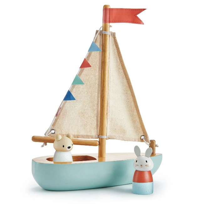Toy sailboat with a colorful sail and two animal figures on a white background