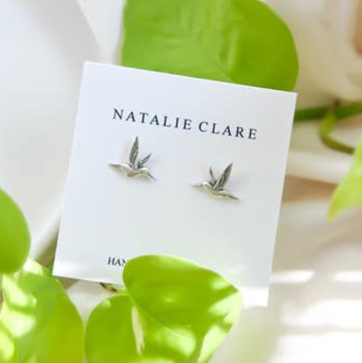 Earring packaging with 'Natalie Clare' branding on a white background with green leaves.
