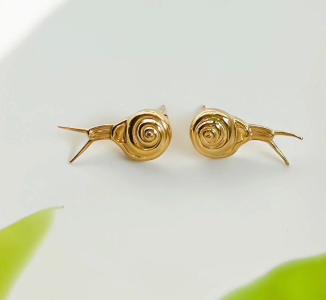 Gold snail-shaped earrings on a light background