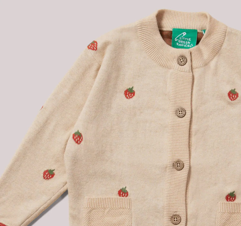 Beige cardigan with strawberry patterns and a visible brand label on a light gray background