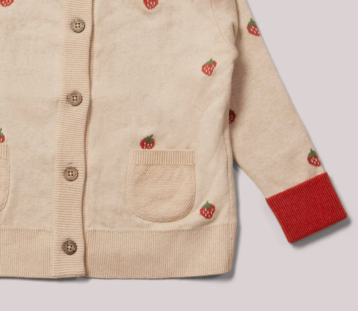 Beige cardigan with red accents and embroidered details on a light gray background
