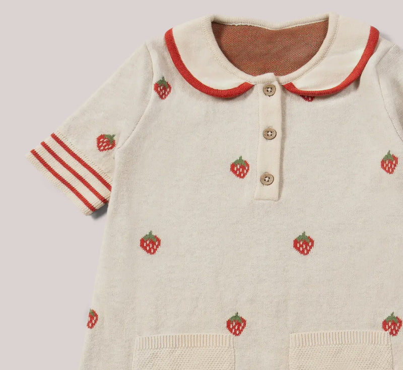 Children's outfit with strawberry pattern on a plain background