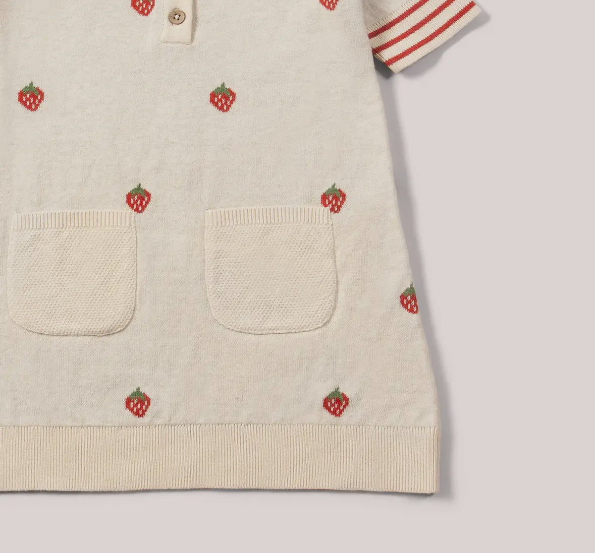 Beige sweater with strawberry patterns on a light gray background