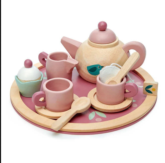 Wooden toy tea set with pink teapot, cups, and utensils on a tray with a white background.