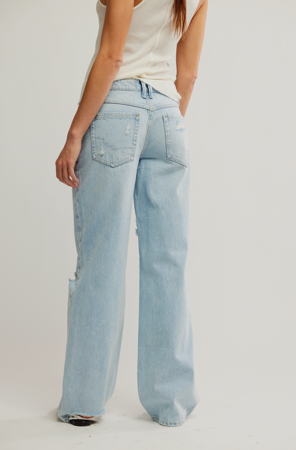 Light blue jeans worn by a person on a plain background