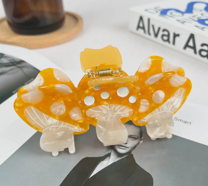 Yellow and white mushroom-shaped hair clip on a magazine background