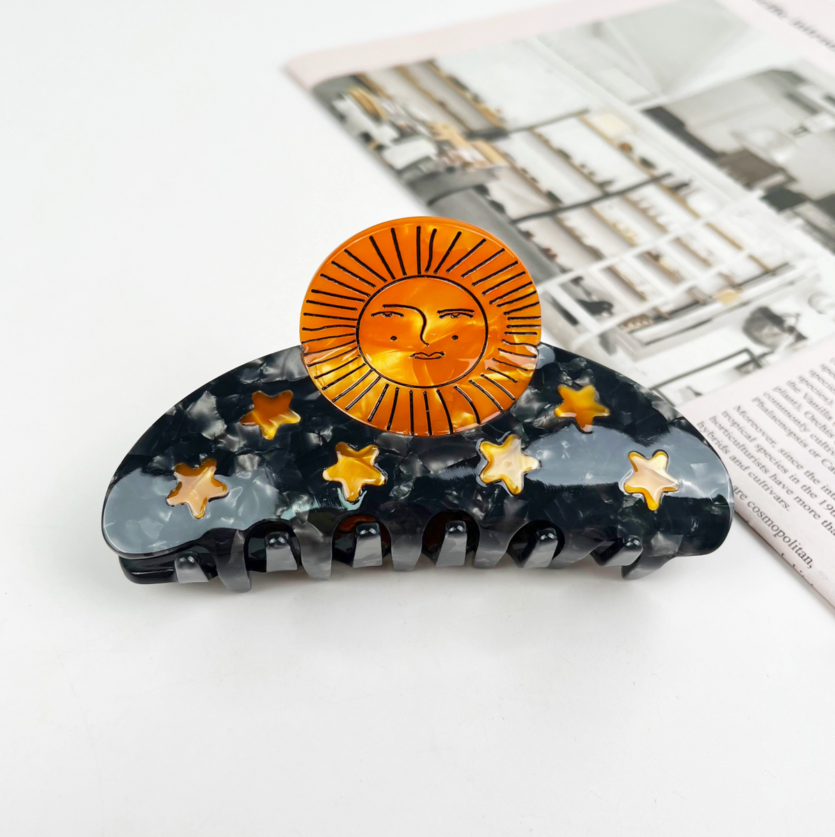 Hair clip with sun and star design on a white background