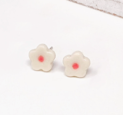 White flower-shaped earrings with a red center 
