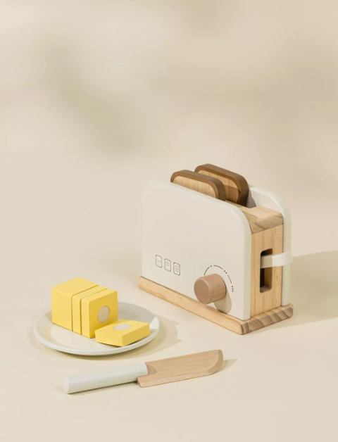 Wooden toaster with slices of bread and butter on a beige background