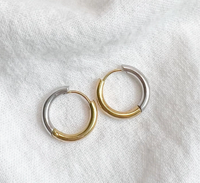 Pair of silver and gold hoop earrings on a white background