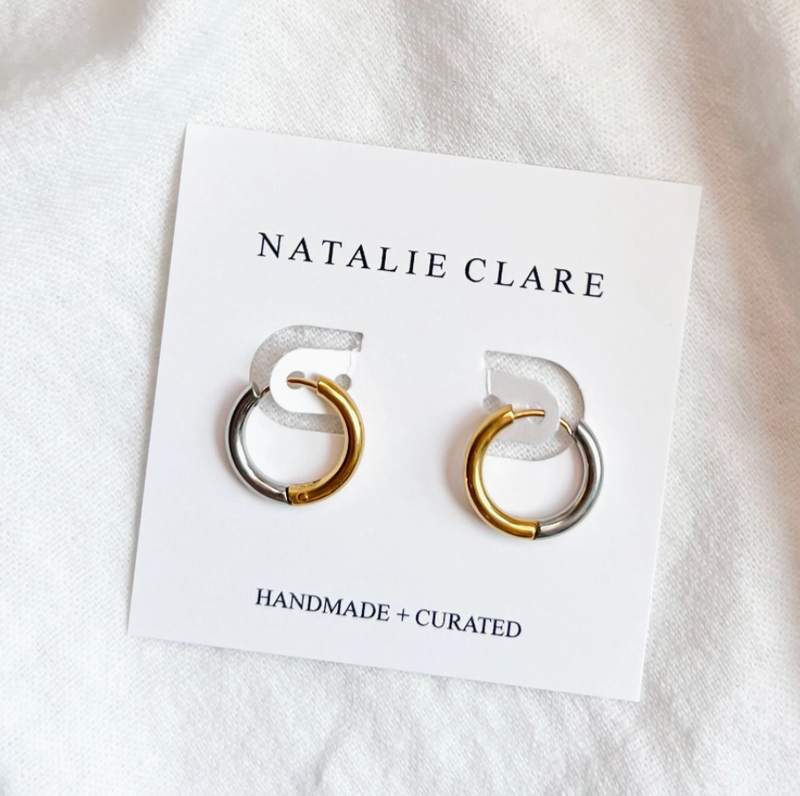 Pair of gold and silver hoop earrings on a 'Natalie Clare' branded card.