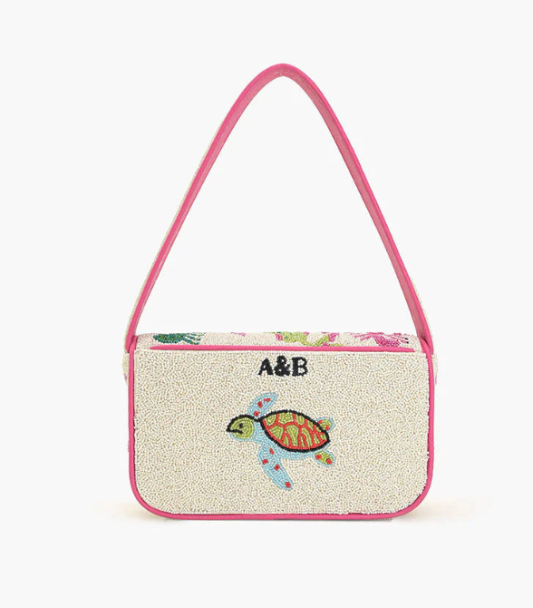 Floral-patterned handbag with a turtle design and initials 'A&B' on a white background