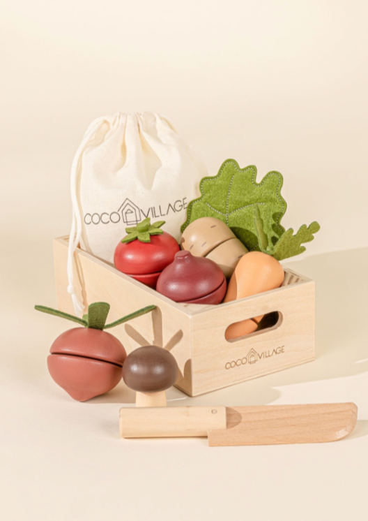 Set of wooden fruits and vegetables with a 'Coco Village' drawstring bag on a beige background