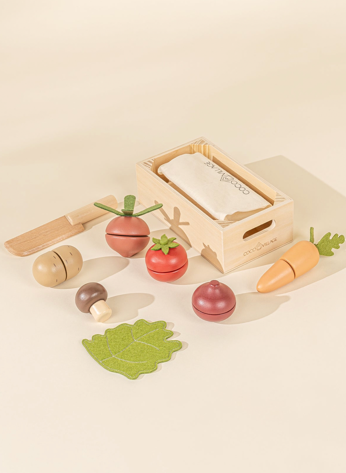 Set of wooden toy vegetables and a box on a beige background