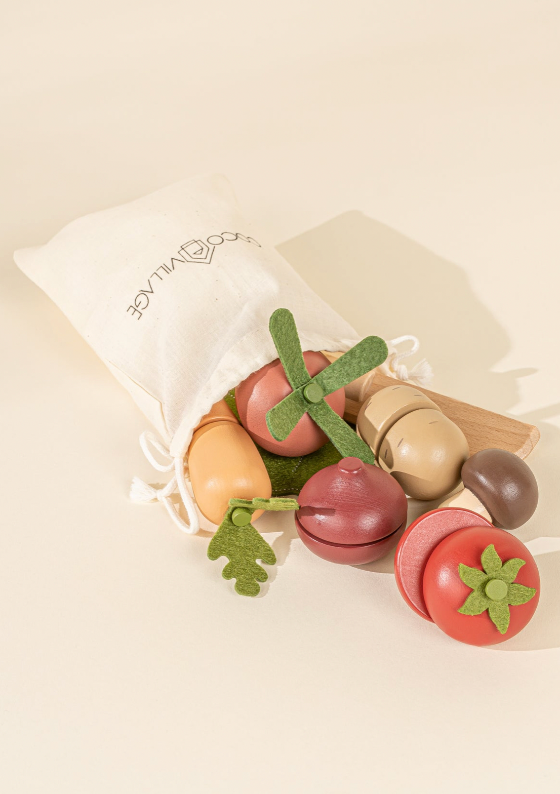 Set of wooden fruits and vegetables with a drawstring bag on a beige background