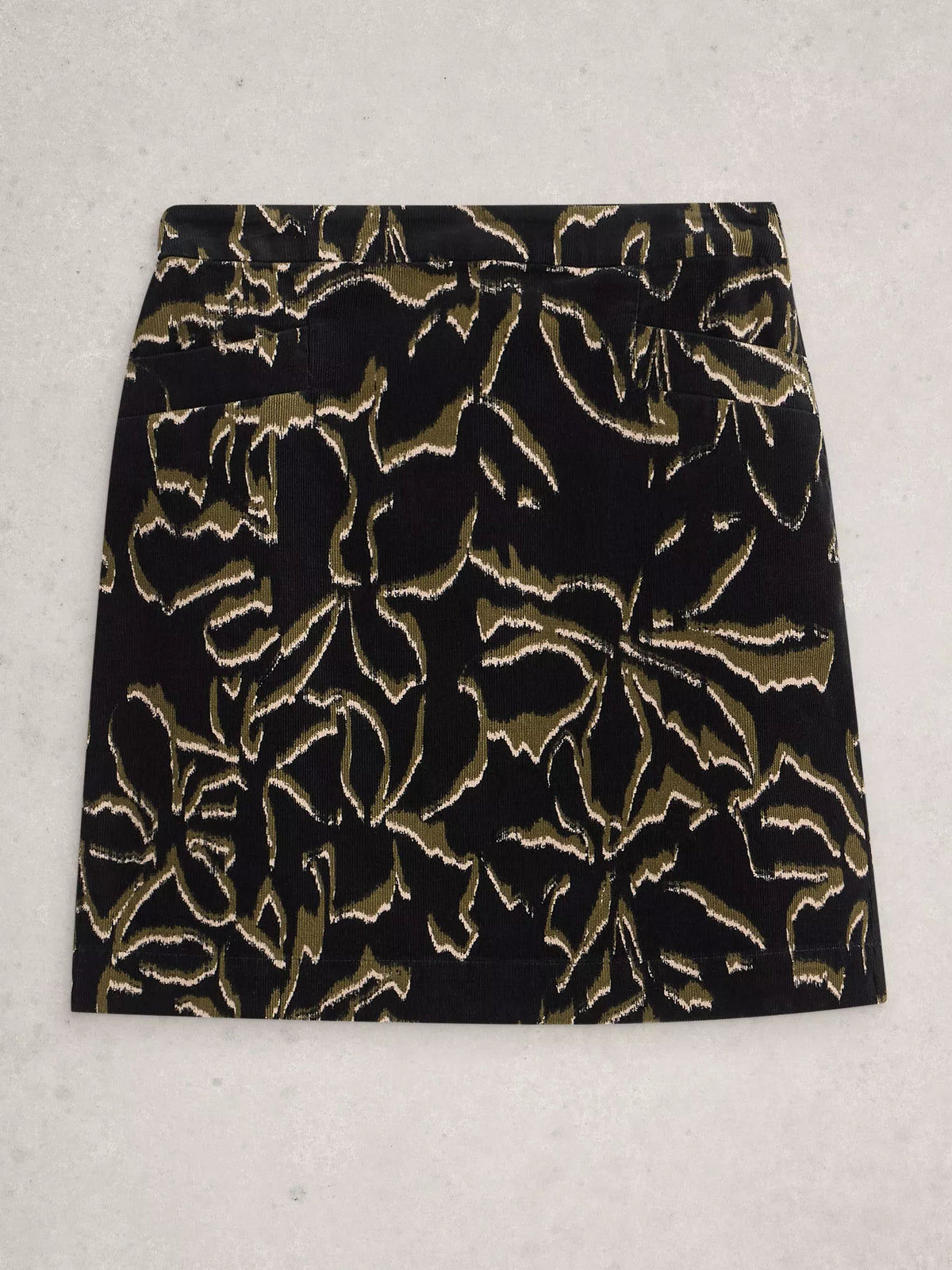 Black skirt with gold floral pattern on a light gray background