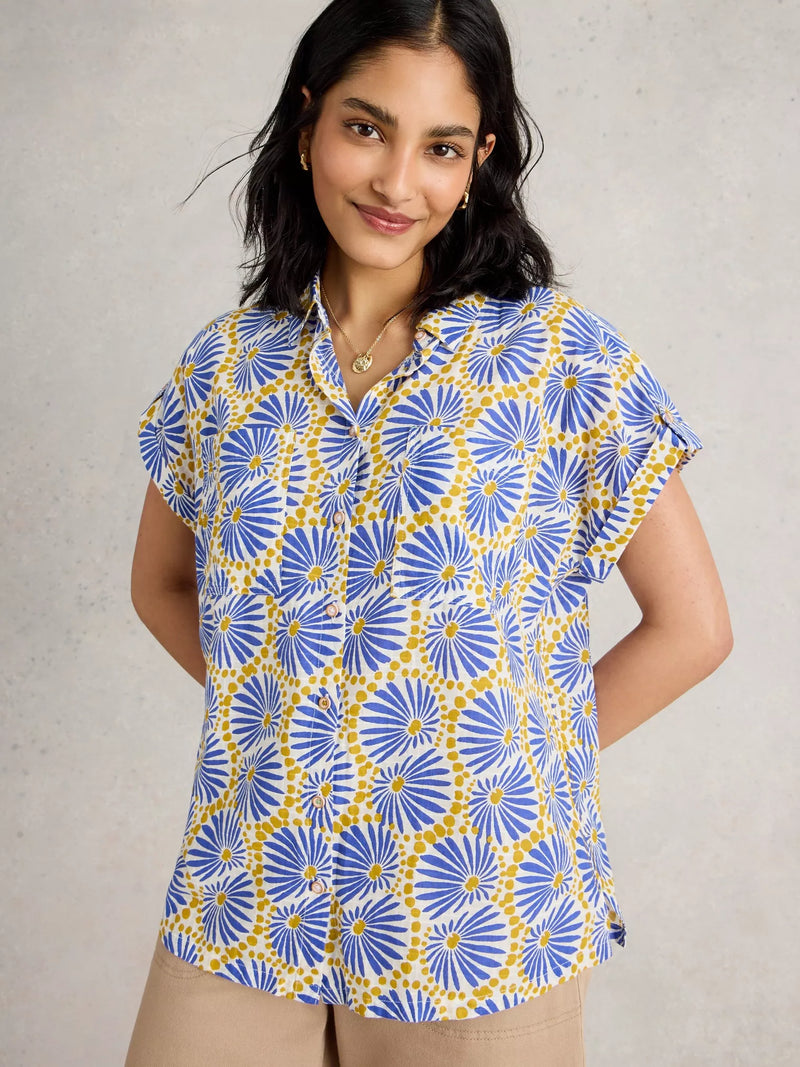 Woman wearing a blue and yellow patterned shirt against a neutral background