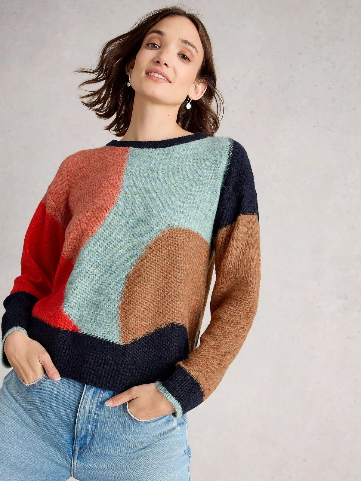 Woman wearing a colorful sweater with a neutral background