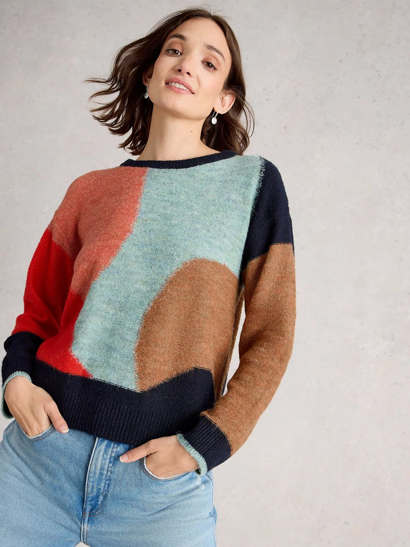 Woman wearing a colorful sweater with a neutral background