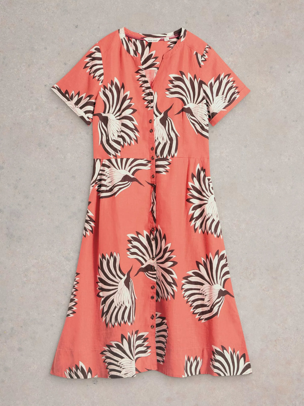 Coral dress with black and white pattern on a gray background