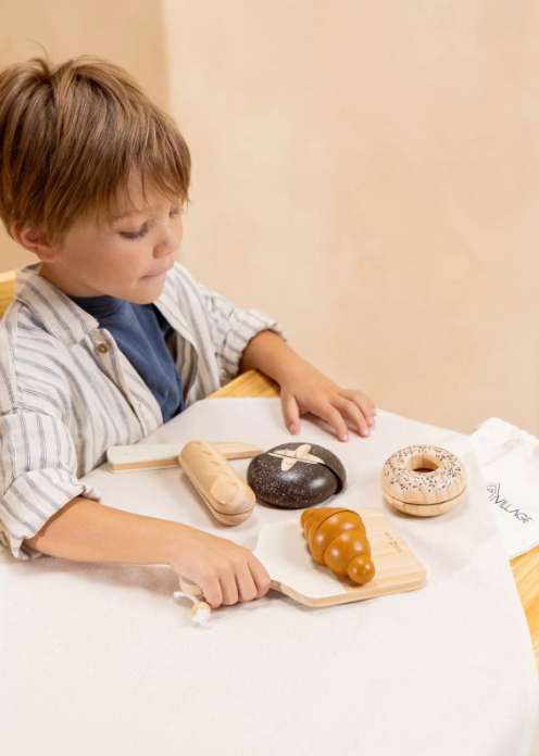 Child playing with toy donuts on a table