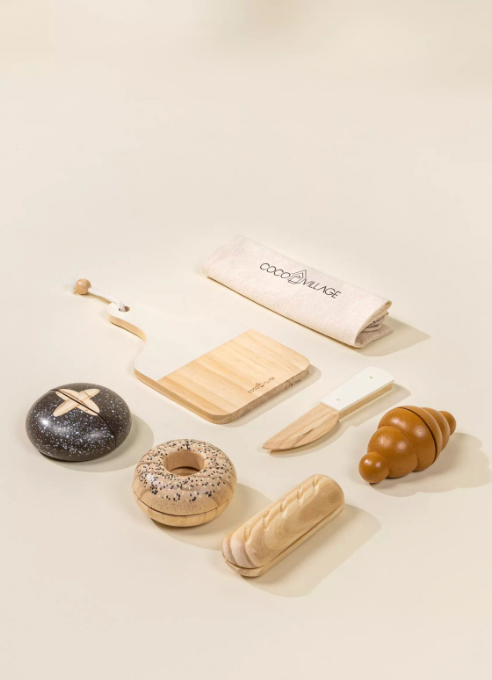 Wooden toy set resembling bakery items on a light surface with 'coconde' branding.