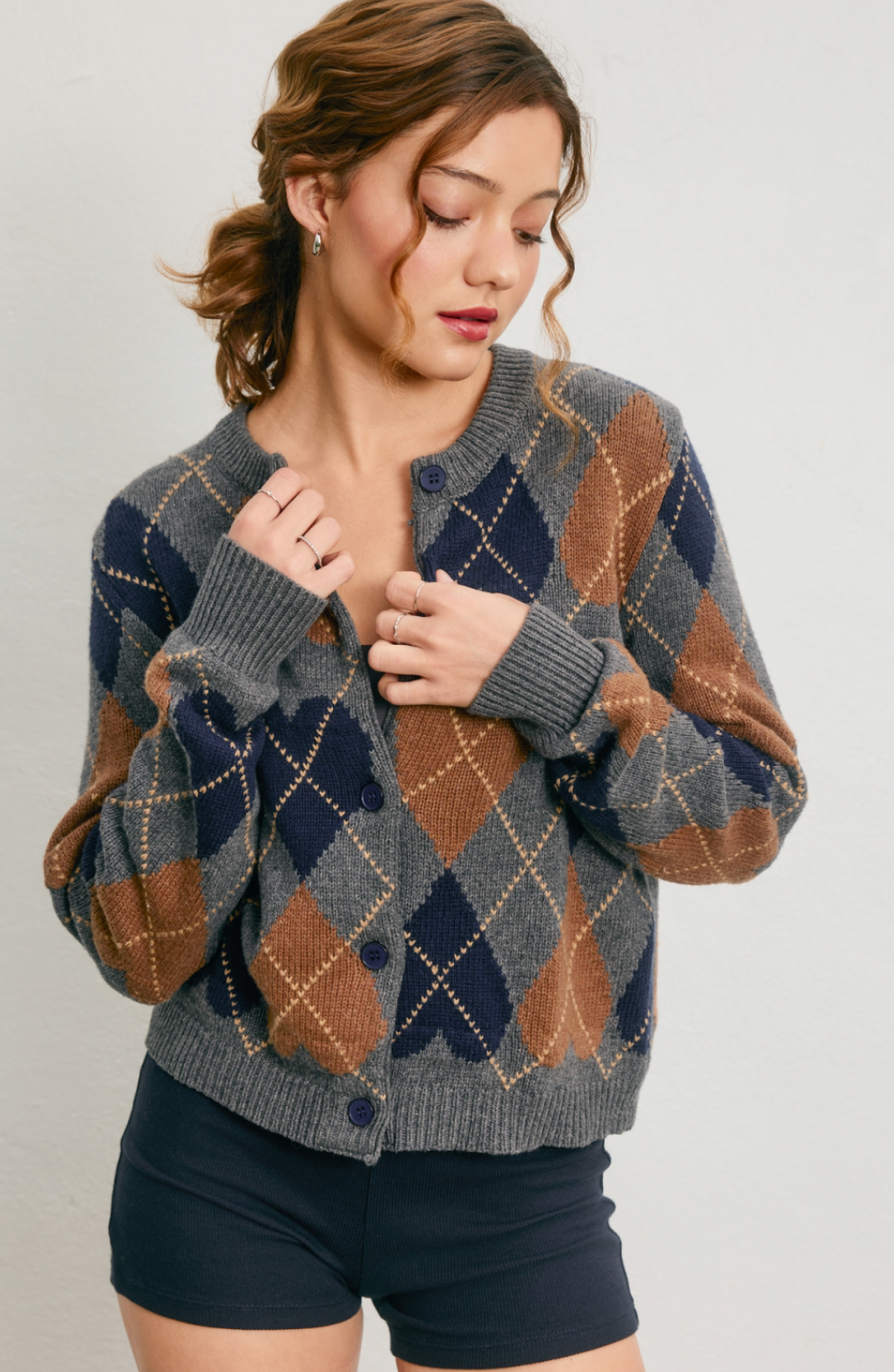 Woman wearing a patterned cardigan on a plain background