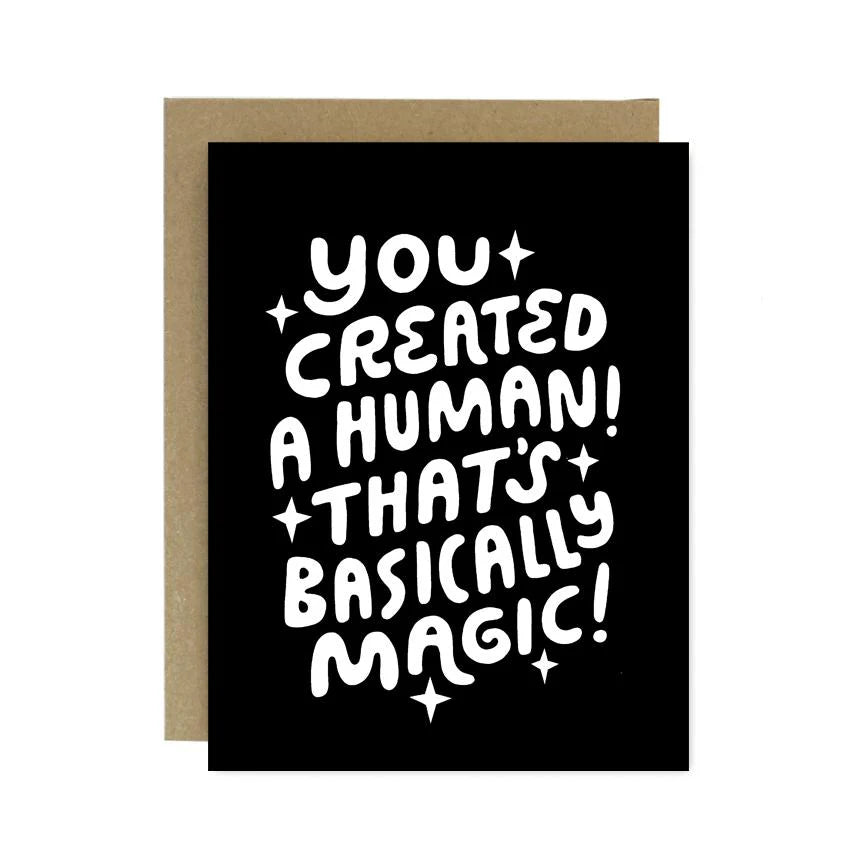 Greeting card with text 'You created a human! That's basically magic!' on a black background with a brown envelope.